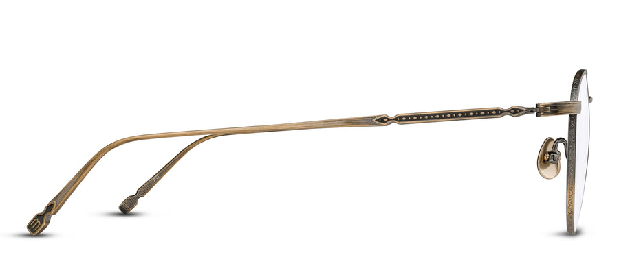 Profile of a pair eyeglasses with an antique gold frame featuring Filigree details, on a white background