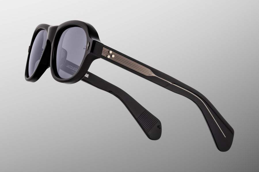 Side profile of round aviator style sunglass frames, in black acetate and grey lenses, with gunmetal gradient hardware.