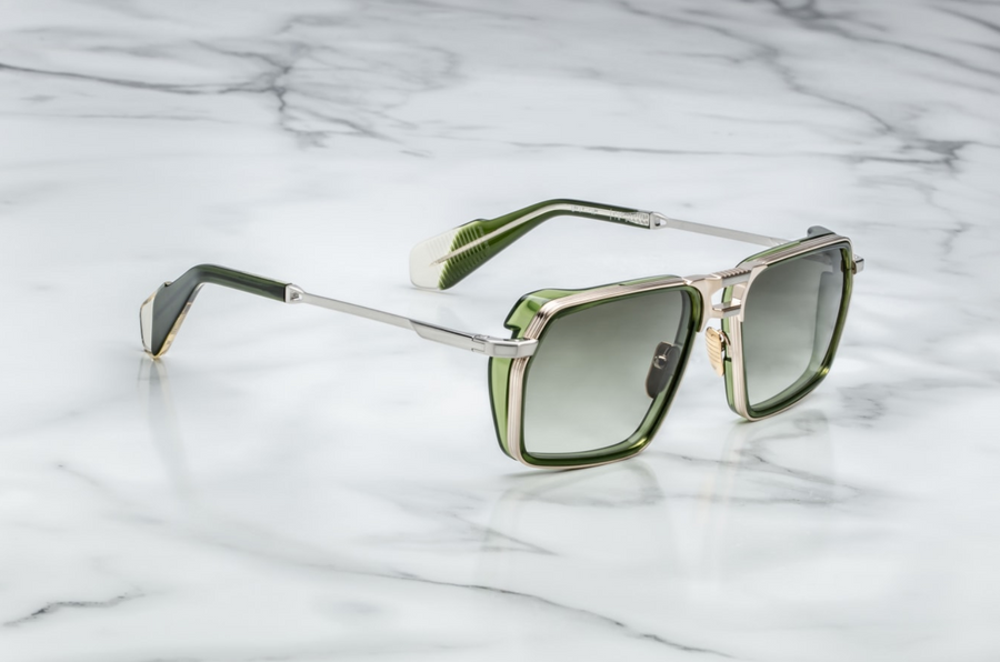 Sunglasses with green and gold frame on a marble background