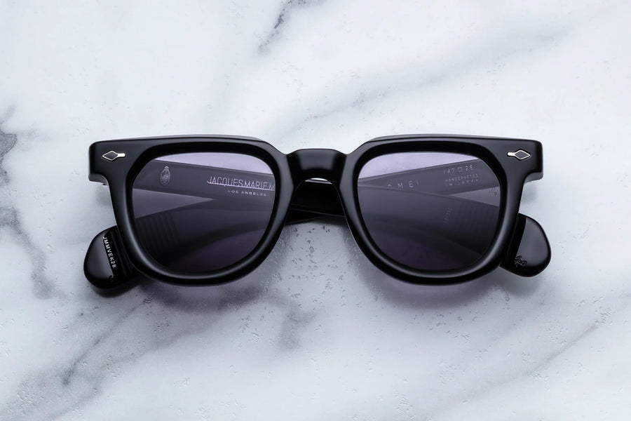Thick black acetate  panto sunglasses with purple lenses on a white marble background