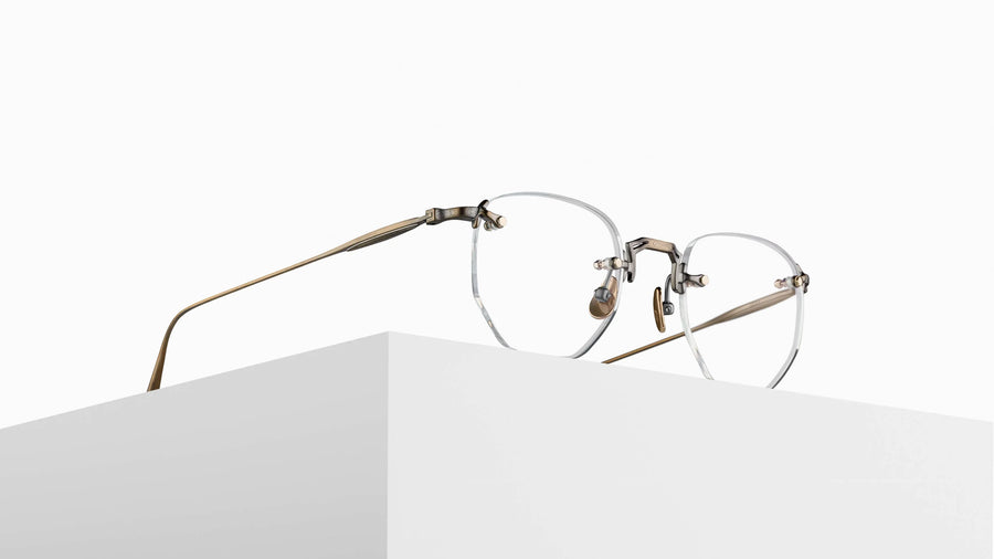 Rimless eyeglasses with gold frame on a white surface